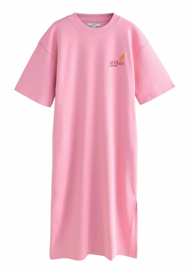 Robe t-shirt oversize rose à manches courtes avec un petit logo Sevilla Andalucía orange et rouge sur le haut gauche de la poitrine et une fente sur le côté.