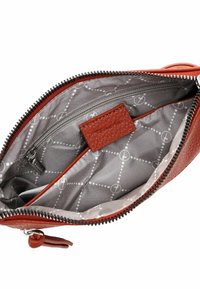 Una borsa a tracolla rossa in pelle con chiusura a zip, caratterizzata da una fodera interna grigia con un motivo a pois e una tasca con zip all'interno.