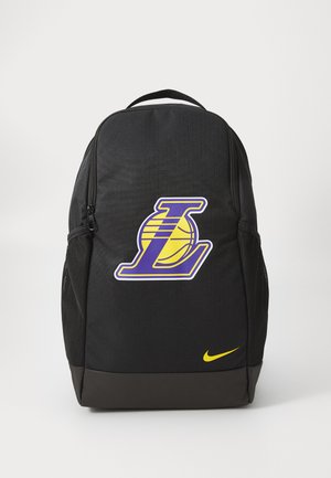 Juodas kuprinė su lygiu paviršiumi, turinti purpurinį ir geltoną Los Andželo „Lakers“ logotipą bei mažą geltoną „Nike“ swooshą apačioje.