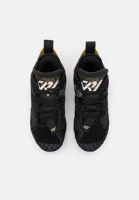 Černé sportovní boty s vrchním sítovým materiálem, zdobené zlatými akcenty a tkaničkami, s nízkým střihem a texturovanou gumovou podrážkou.