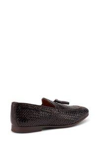 Mocassino in pelle intrecciata marrone con punta arrotondata, nappine decorative e accenti elastici laterali; presenta un profilo basso e una suola morbida.