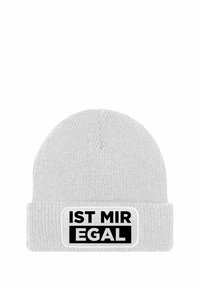 White knit beanie with a folded cuff; features a rectangular patch with black text "IST MIR EGAL" on a white background.