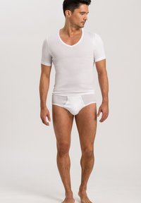 Weißes Kurzarm-V-Ausschnitt-T-Shirt und weiße Unterwäsche an einer Person. Der Stoff wirkt glatt und leicht; körperbetontes Design. Schlichter, moderner Stil.