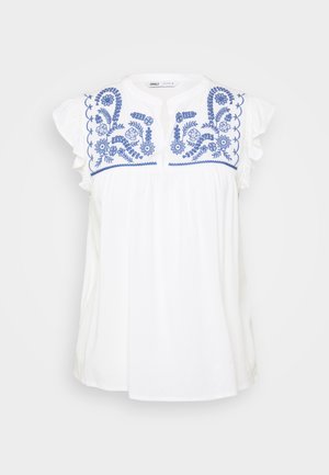 Fehér pamut blúz kék virágos hímzéssel és fodros ujjal. Kerek dekoltázsa és lazán álló combja van.