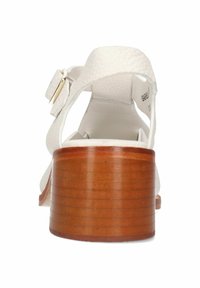 Sandalia de cuero blanco con correa ajustable, tacón de bloque de madera y suela texturizada. Presenta un acabado suave y un diseño minimalista.