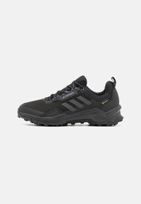Schwarzer Outdoor-Schuh mit strukturiertem Obermaterial, gepolstertem Sohlen und strapazierfähiger Außensohle für Traktion. Akzente sind Logo-Streifen und das GORE-TEX-Label.
