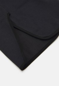 Must tannittekiga tekk, millel on sile pind ja pehme, tekstuuriga sisemus. Servad on viimistletud kontrastset musta äärisega.