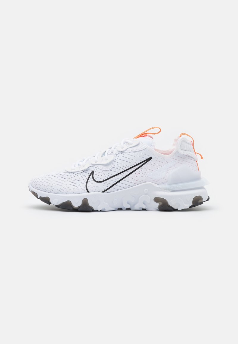 Chaussure de sport Nike blanche avec un swoosh noir, tige en mesh respirant, semelle blanche texturée et languettes orange sur la languette et le talon.