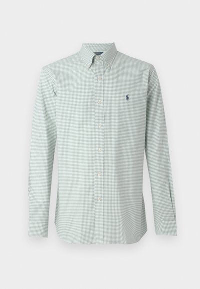 Gaiši zaļš ģeometrijas raksta poga uz augšu krekls ar garām piedurknēm, klasisko apkakli un mazo tumši zilo logo uz krūtīm. Iezīmes baltas pogas un teksturēta auduma.