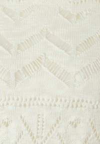 Tissu tricoté blanc avec un motif texturé comportant des formes de diamant alternées et des détails ajourés, créant une apparence légère et aérée.