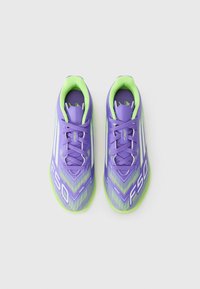 Paarse voetbalschoenen met groene accenten, voorzien van een gestructureerd oppervlak en bedrukte strepen. Vetersluiting met 'F50' branding aan de zijkant.