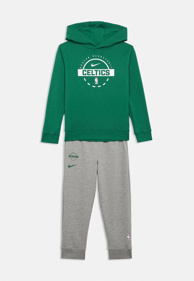 Sweatshirt verde com os logótipos dos Boston Celtics e da Nike, combinado com calças de fato cinzentas com os logótipos dos Celtics, da Nike e do emblema da NBA na perna.