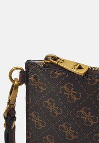 Braune, gemusterte Tasche mit Lederoptik, ausgestattet mit einem goldenen Reißverschluss und goldenen Beschlägen. Das Design umfasst ein sich wiederholendes Logo-Muster.