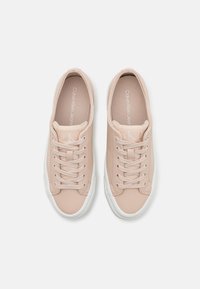 Calvin Klein tornacipők puha rózsaszín szintetikus anyagból, fehér gumi talppal. Jellemzők közé tartozik a fűző és a márkajelzés a talpbélésen.