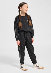 Schwarzer sweatshirt mit geflecktem Muster, gerippten Bündchen und passenden Jogginghosen. Weiße Seitenstreifen an den Hosen. Weiße Schuhe mit schwarzen Akzenten.