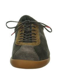 Grijze, bruine en zwarte suède sneakers met bruine veters in een strik gebonden en een gumrubberen zool, bekeken vanaf de voorkant.