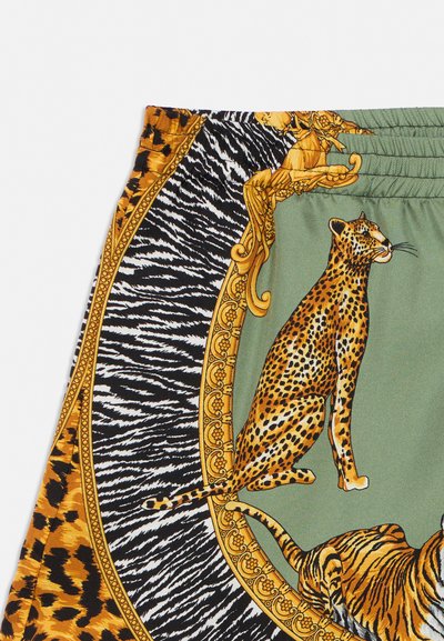Shorts avec des panneaux à imprimés verts, zèbre et léopard, avec un cadre en or orné et des illustrations d’un guépard et d’un tigre assis.