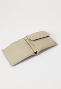Beige lommebok laget av glatt skinn, med klaffelukking, flere kortlommer og en myk innvendig tekstur. Embossert logo-detalj til stede.