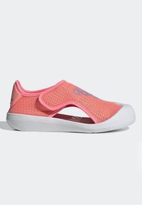 Scarpa slip-on in mesh rosa con suola in gomma bianca, lati aperti e cinturino in Velcro. Presenta il logo blu sul lato superiore.