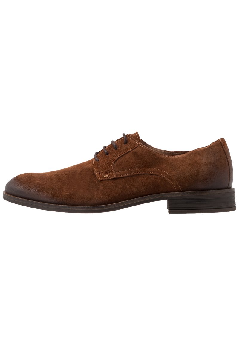 Chaussure de ville en suède marron avec un bout arrondi, des lacets en cuir et un talon plat. Détail de couture sur le dessus et semelle lisse.