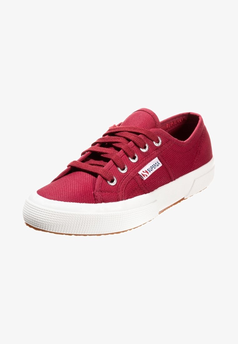 Baskets basses en toile rouge avec semelle en caoutchouc blanche et lacets, avec une petite étiquette logo "Superga" sur le côté.