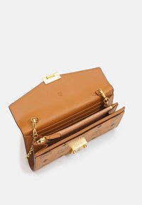 Cartera de cuero marrón con herrajes dorados, que cuenta con un compartimento con cremallera y múltiples ranuras para tarjetas. Patrón en relieve notable en el exterior.