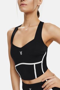 Black fitted sports crop top with wide straps, white accents, and a heart logo on the center. Textured stretch material.