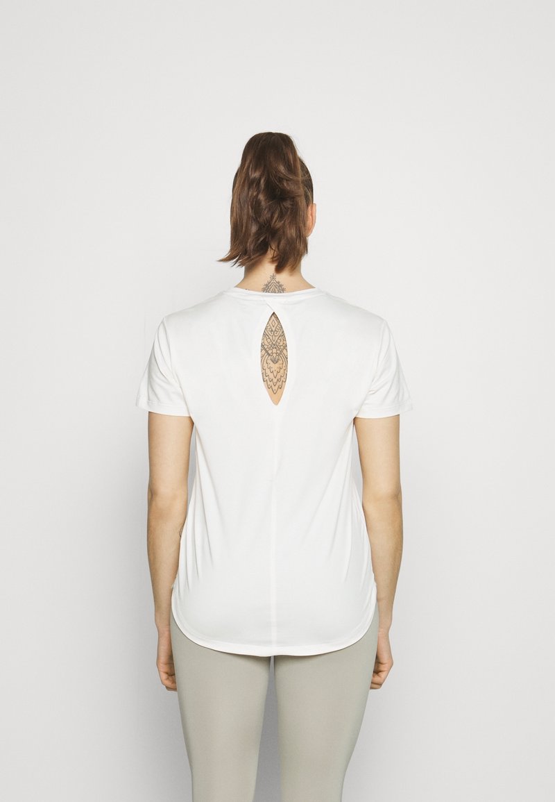 Witte t-shirt met korte mouwen en een sleutelgatcut-out aan de achterkant, van zachte stof en met een relaxte pasvorm. Draag het met lichtgekleurde leggings.
