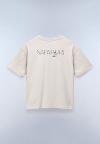 Lys beige bomulds t-shirt med korte ærmer, som har et trykt logo og karakterdesign på ryggen. Glat tekstur og afslappet pasform.