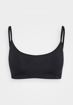 Svart bralette med tynne justerbare stropper, sømløst design, elastisk stoff og en subtil logo på bunnen. Jevn tekstur.