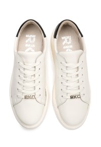 Białe skórzane sneakersy o gładkiej fakturze, z czarnym akcentem na pięcie, sznurowanym zapięciem i wytłoczonym logo "RKO" na boku.