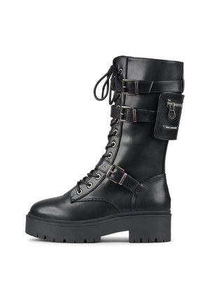 Czarny skórzany wojskowy but z grubą podeszwą, sznurowany z przodu, z trzema regulowanymi paskami z klamrami oraz małą zapinaną na suwak kieszonką przymocowaną w pobliżu góry.