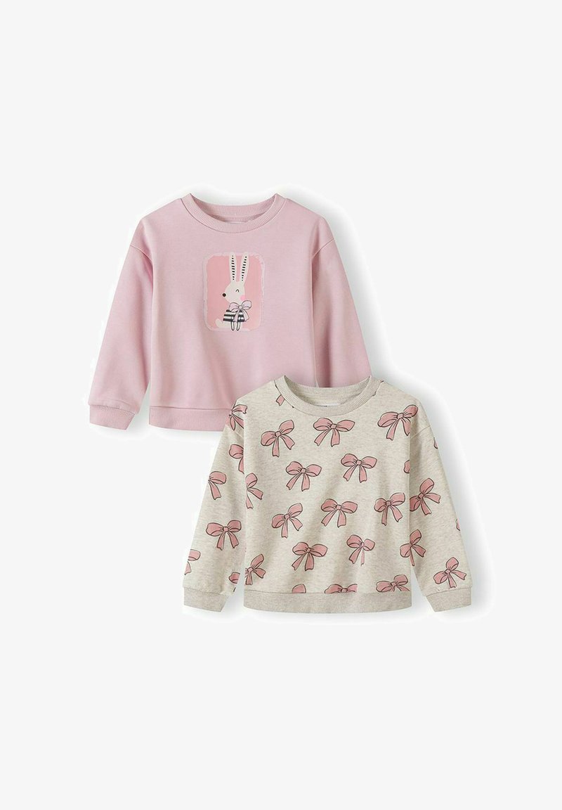 Deux sweat-shirts pour enfants : un rose avec un lapin tenant un arc, l'autre beige avec un motif de nœuds roses.