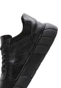Baskets en cuir noir avec un bout arrondi, des panneaux texturés, des lacets plats et une semelle en caoutchouc épaisse avec un motif cranté.