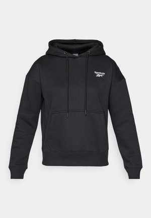 Juodas gobtuvas megztinis, pagamintas iš minkštos, tekstūruotos medžiagos. Yra priekinė kišenė ir balta Reebok logotipas ant krūtinės.