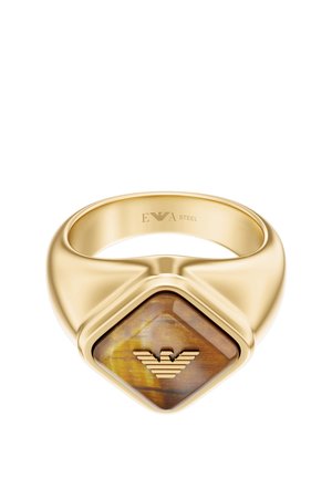 Goldfarbener Metallring mit einem quadratischen braunen Tigerauge-Stein und einem stilisierten Adlerlogo auf der Vorderseite.