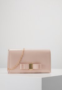 Růžové psaníčko z lakované kůže se zlatým řetízkovým popruhem, zdobené velkou mašlí a obdélníkovou zlatou sponou na přední straně.