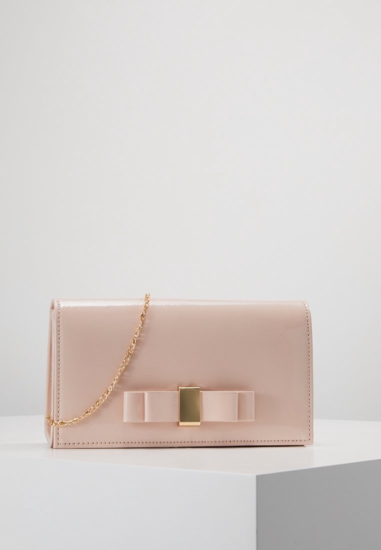 Růžové psaníčko z lakované kůže se zlatým řetízkovým popruhem, zdobené velkou mašlí a obdélníkovou zlatou sponou na přední straně.