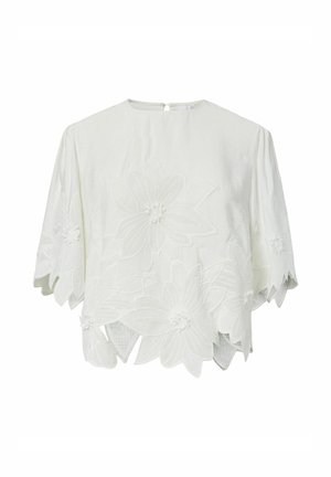 Hvid kortærmet bluse med store broderede blomsterdesigns og bølgede kanter på kant og ærmer.