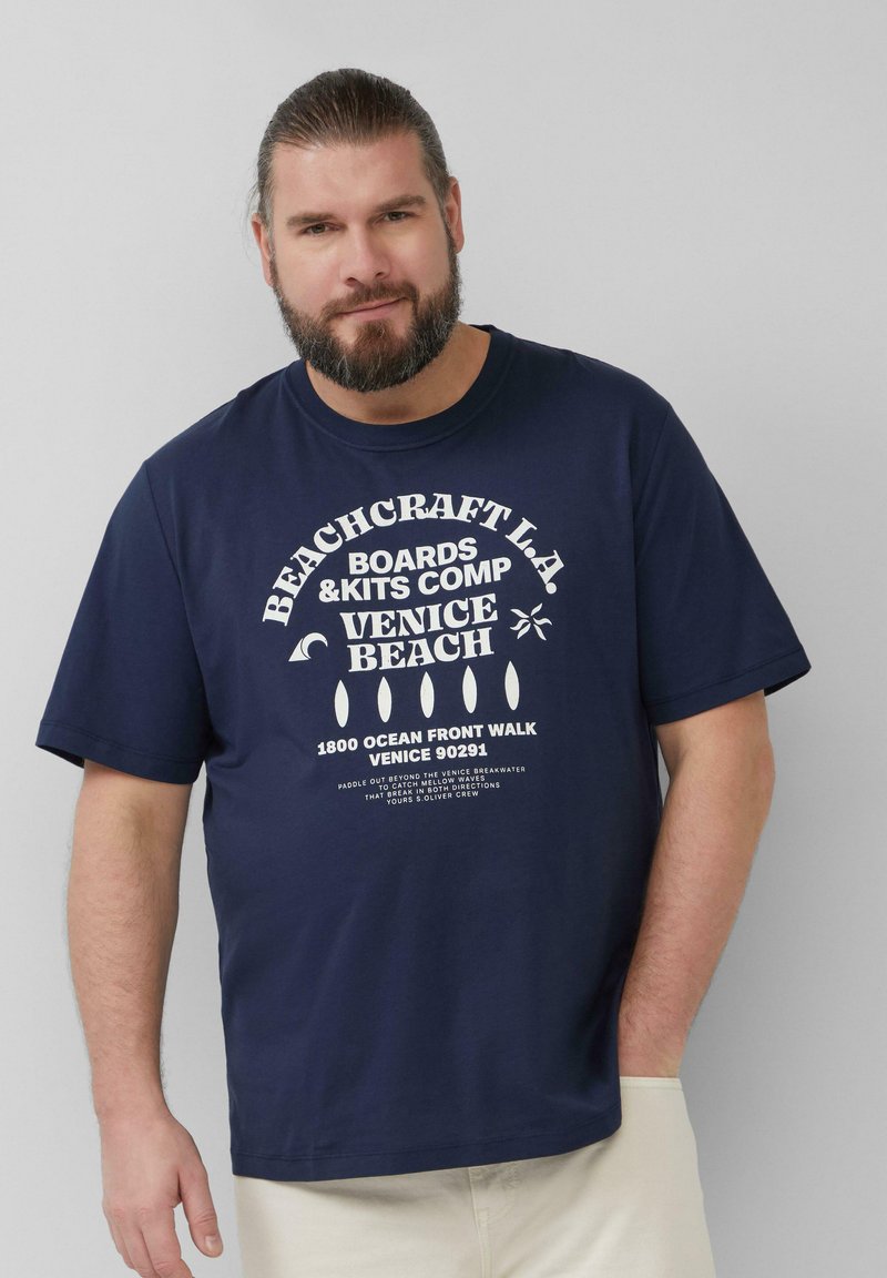 Navyblauwe katoenen T-shirt met witte tekst in een vintage strandthema. Korte mouwen en een ontspannen pasvorm.