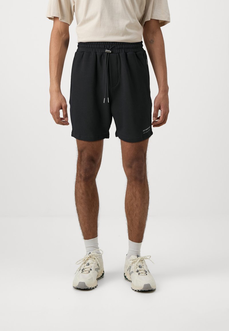 Black cotton shorts with an elastic waistband and a drawstring. The design includes side pockets and a small logo on the lower hem.