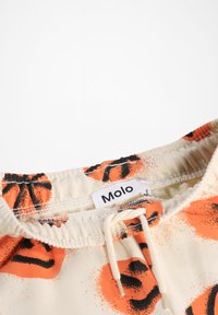 Molo shorts med elastisk talje, der har en cremefarvet baggrund og et orange-sort leopard-print mønster samt en snoretræk detalje.