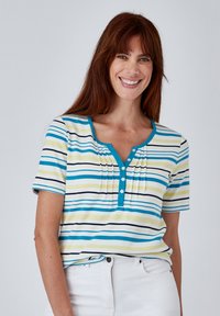 Camisa de manga corta a rayas con franjas azules, amarillas y negras. Cuello redondeado con tapeta de botones y detalles de pliegues.