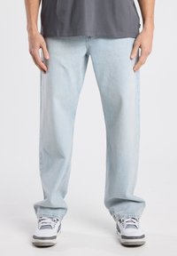 Lichtblauwe denim jeans met een relaxte pasvorm. De stof heeft een licht verweerde textuur en is afgewerkt met een rechte zoom bij de enkels.