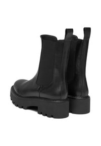 Czarne skórzane botki za kostkę z elastycznymi panelami bocznymi, uchwytami do zakupu i masywną gumową podeszwą z głębokim bieżnikiem zapewniającym dobrą przyczepność.