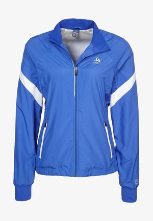 Chaqueta ligera azul con cremallera completa, franjas diagonales blancas en las mangas, puños elásticos y dos bolsillos laterales con cremallera.
