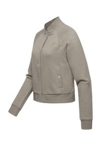 Light gray cropped jacket, smooth fabric, round collar, snap buttons, ribbed cuffs, side pockets, with tonal logo detail on the chest.