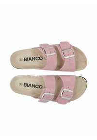 Sandali in suede rosa con due cinturini regolabili, fibbie in argento e soletta imbottita beige. Suola nera piatta, design minimalista.