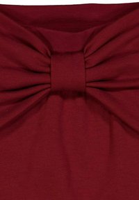 Bordó látka s velkou mašlí uprostřed. Hladký povrch, rovnoměrně prošitý, vytvářející nabíraný efekt kolem mašle.