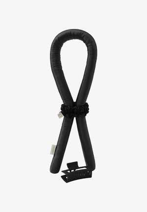 Zwarte haarkrultang bedekt met stof, met een bijpassende scrunchie en een zwarte plastic haarclip met klauw, op een witte achtergrond.